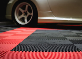 white car on red and black Swisstrax Ribtrax Pro tiles