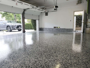 light shining in through the open door of a customized garage with poly flake flooring and custom cabinets