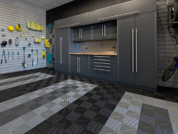 garage renovation featuring interlocking floor tiles, steel cabinets, and a slat wall for tool organization
